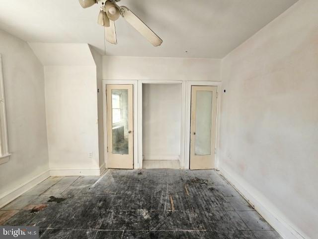 empty room featuring lofted ceiling and ceiling fan