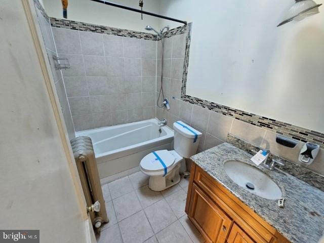 full bathroom featuring tiled shower / bath combo, radiator heating unit, vanity, tile patterned floors, and toilet