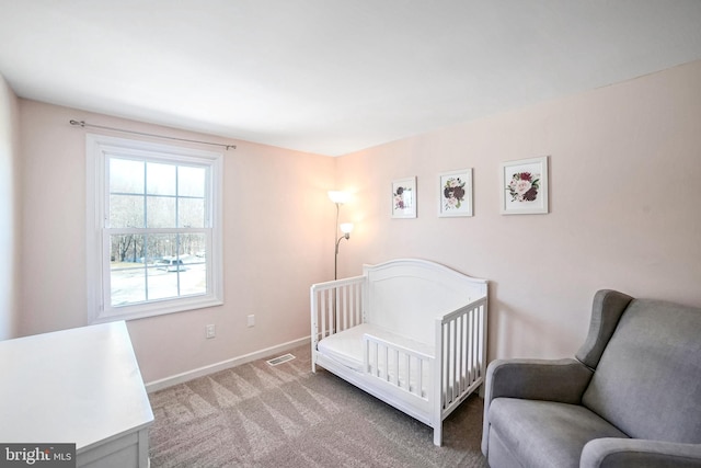 carpeted bedroom featuring a nursery area