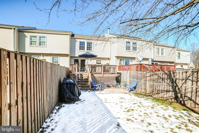 snow covered house featuring a deck