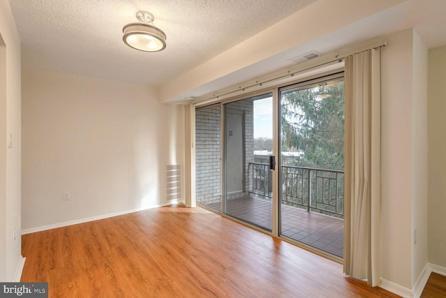 empty room featuring hardwood / wood-style flooring and a textured ceiling