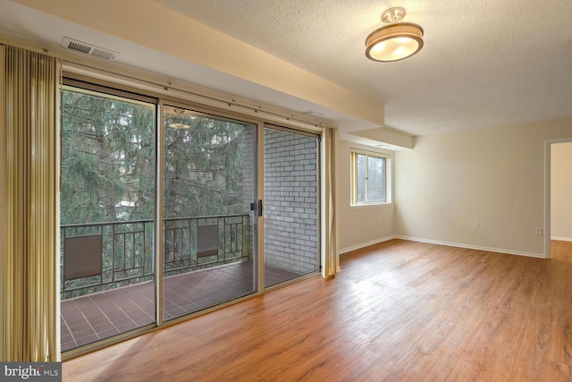 unfurnished room featuring hardwood / wood-style floors and a textured ceiling