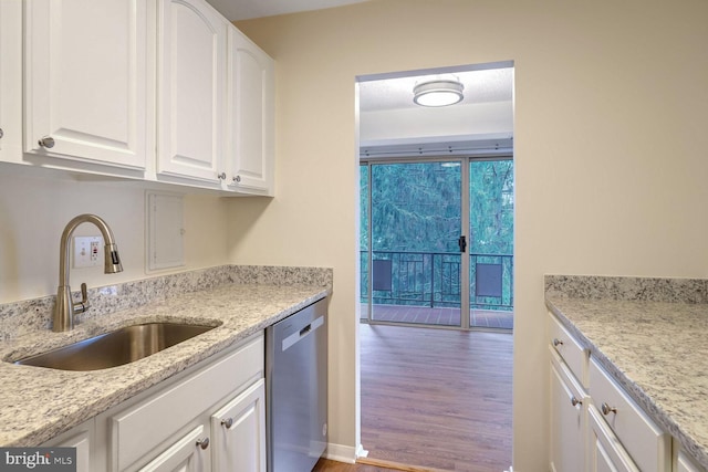 kitchen with floor to ceiling windows, sink, white cabinetry, light stone counters, and dishwasher