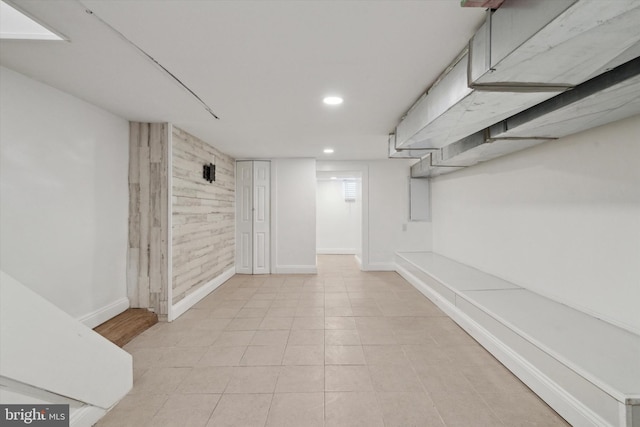 basement featuring wooden walls