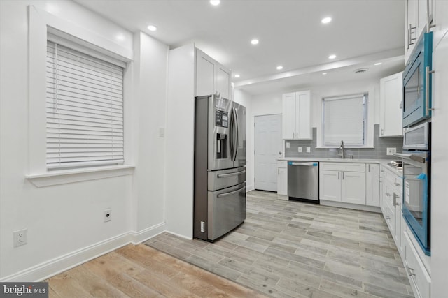 kitchen featuring white cabinetry, appliances with stainless steel finishes, sink, and decorative backsplash