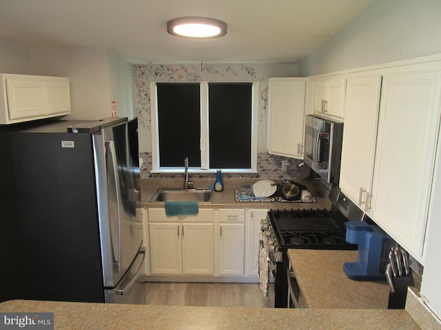 348 Broad St, Mount Holly, NJ 08060 - kitchen featuring appliances with stainless steel finishes, a sink, white cabinetry, and light countertops