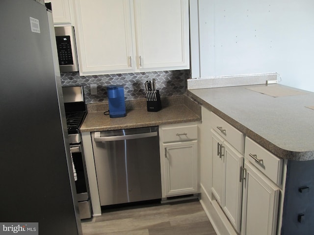 348 Broad St, Mount Holly, NJ 08060 - kitchen featuring stainless steel appliances, a peninsula, light wood-style floors, and white cabinets