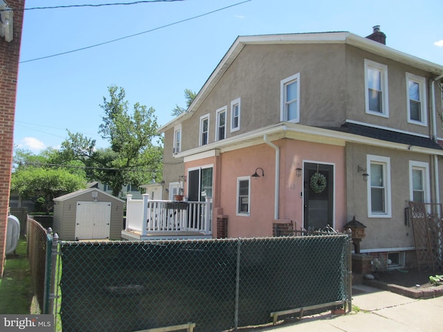 348 Broad St, Mount Holly, NJ 08060 - view of front of home featuring stucco siding, fence, and a storage unit