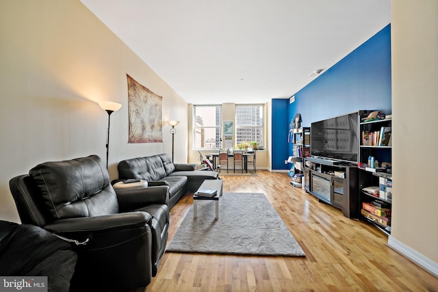 living area featuring baseboards and light wood-style floors