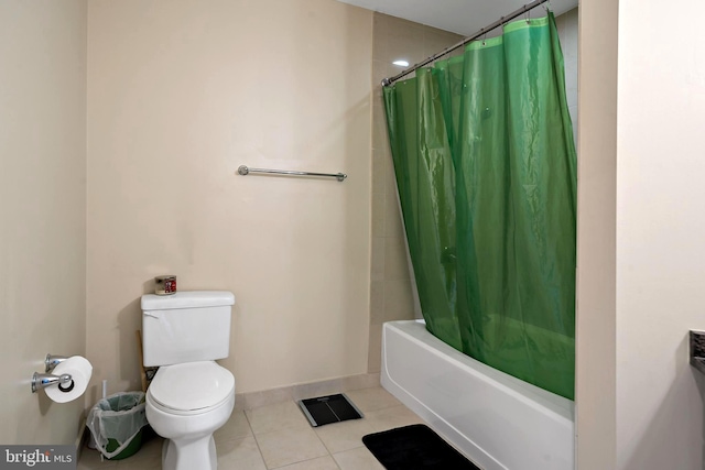 full bath with tile patterned flooring, toilet, shower / tub combo with curtain, and baseboards