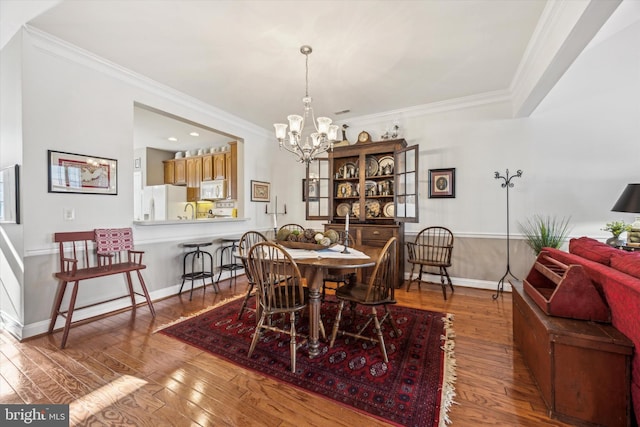 dining space featuring crown molding, a chandelier, and light hardwood / wood-style flooring