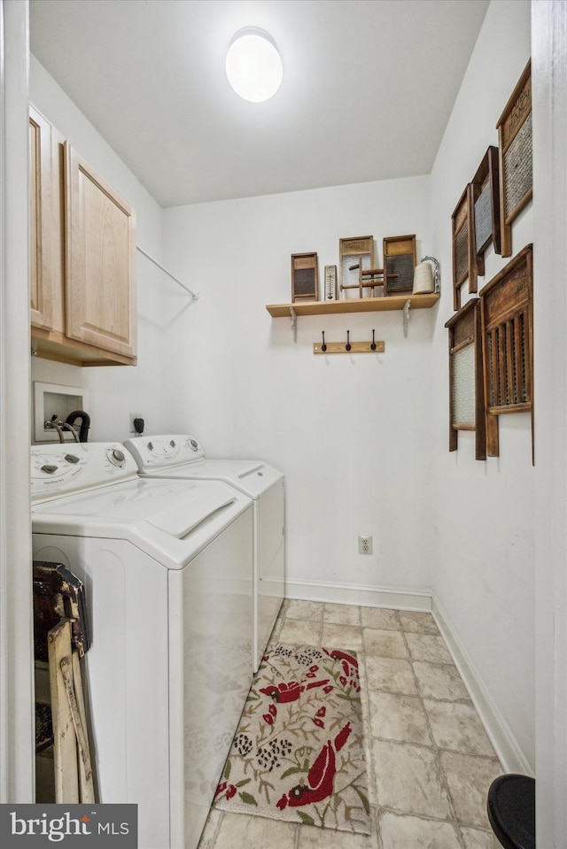 clothes washing area featuring cabinets and washing machine and clothes dryer