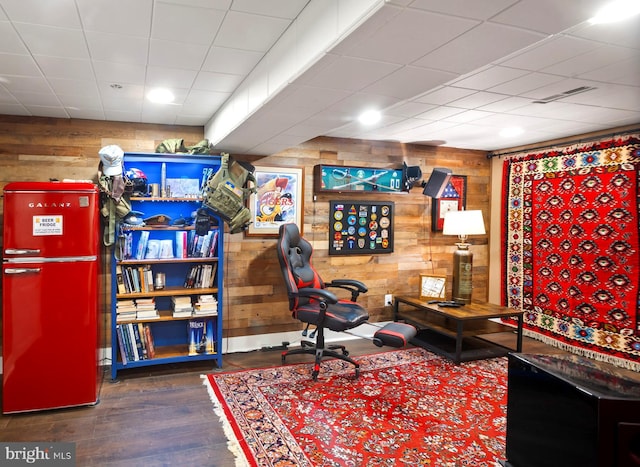 living area with wood-type flooring and wooden walls