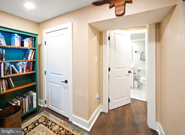 corridor with dark hardwood / wood-style flooring