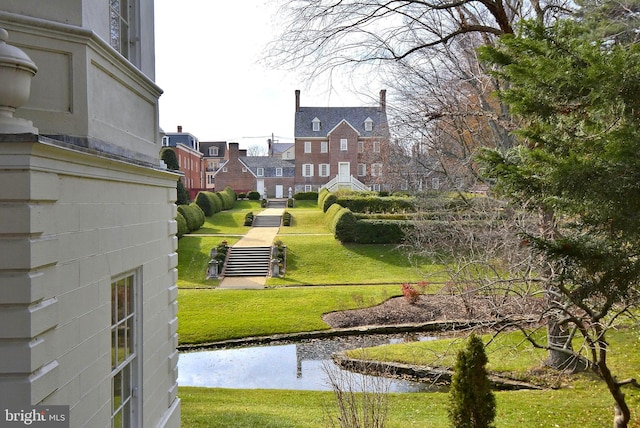 surrounding community featuring a water view and a lawn