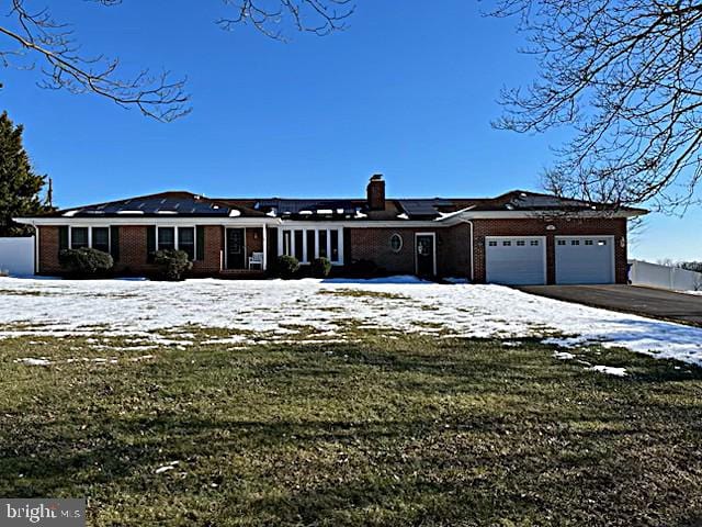 single story home featuring a garage and a lawn