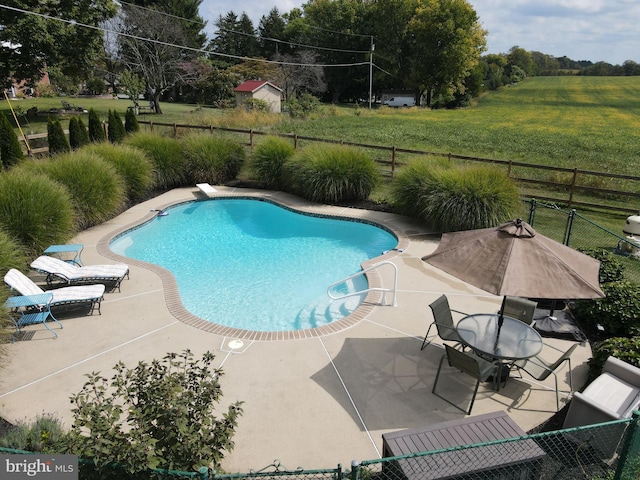 view of pool with a diving board, a patio, and a lawn