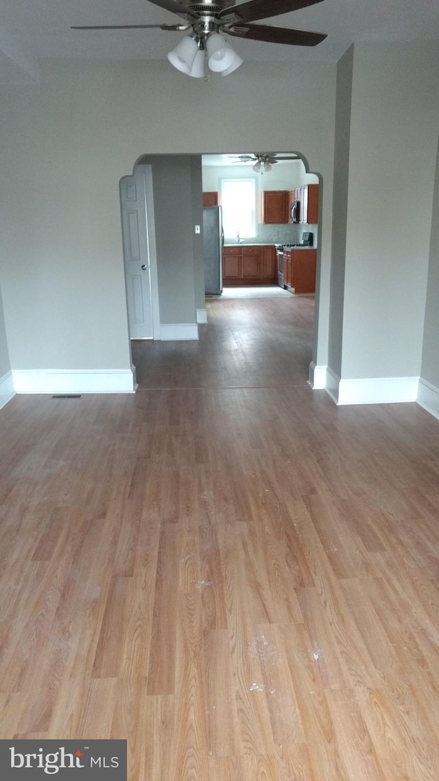 spare room with ceiling fan and light wood-type flooring