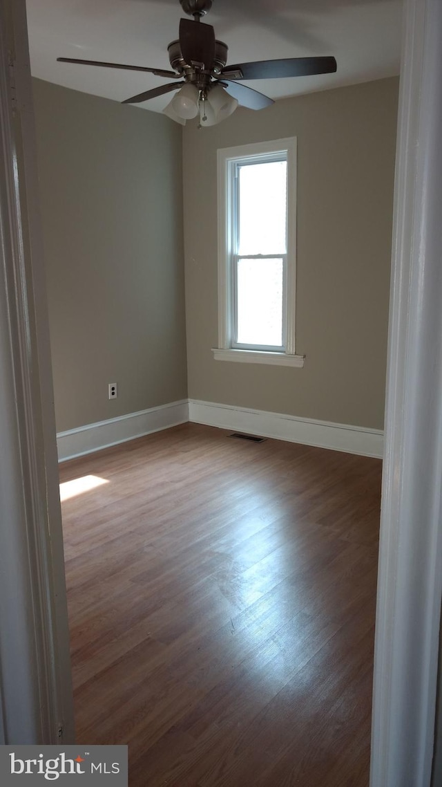 empty room with hardwood / wood-style flooring and ceiling fan