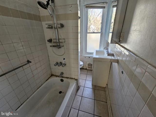 bathroom with tile patterned floors, vanity, toilet, and tile walls