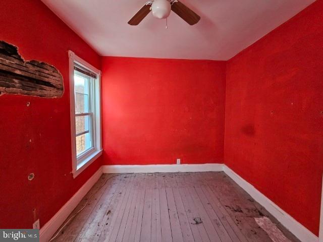 spare room with plenty of natural light, hardwood / wood-style floors, and ceiling fan