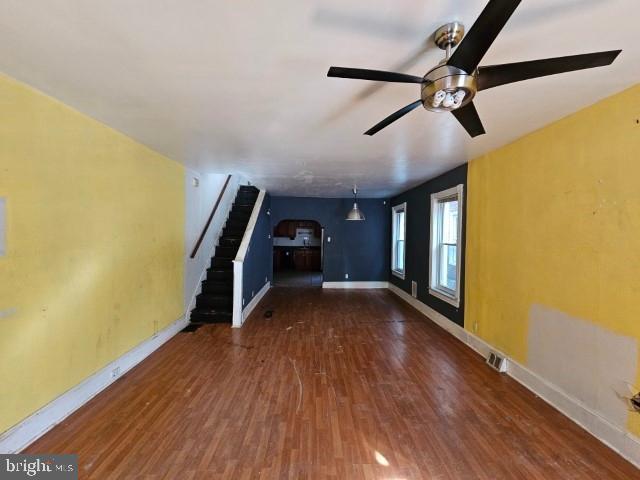 unfurnished living room with dark wood-type flooring and ceiling fan