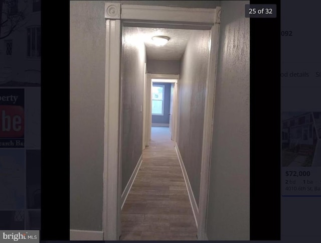 hallway featuring hardwood / wood-style flooring and a textured ceiling