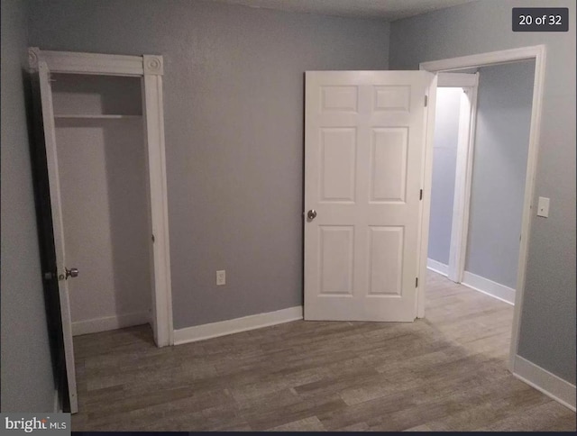 unfurnished bedroom featuring hardwood / wood-style floors and a closet