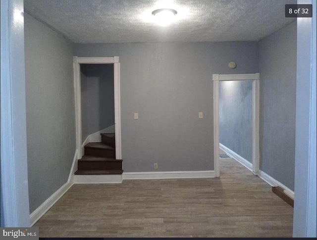 empty room with hardwood / wood-style flooring and a textured ceiling