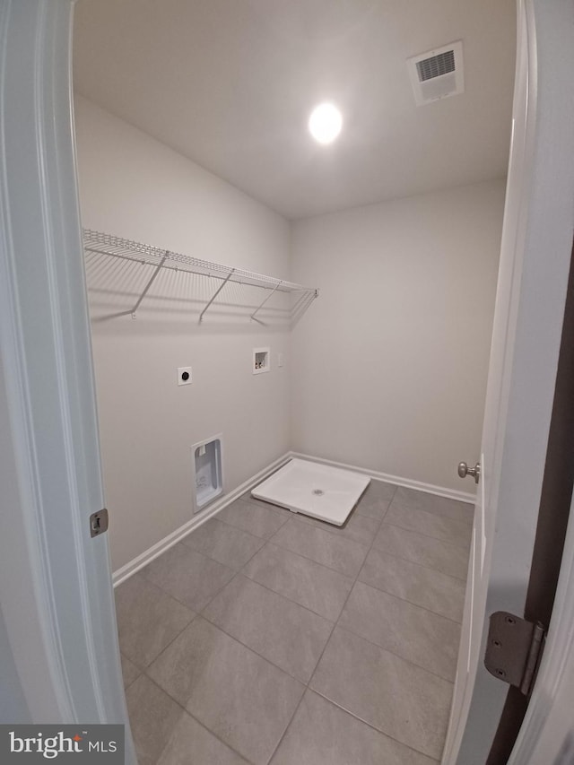 washroom with electric dryer hookup, light tile patterned floors, and hookup for a washing machine