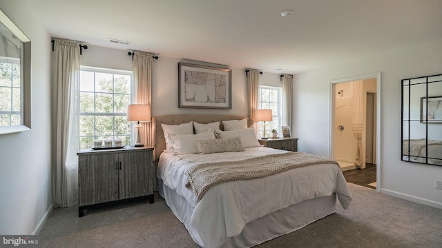 bedroom featuring ensuite bath, radiator, and dark carpet