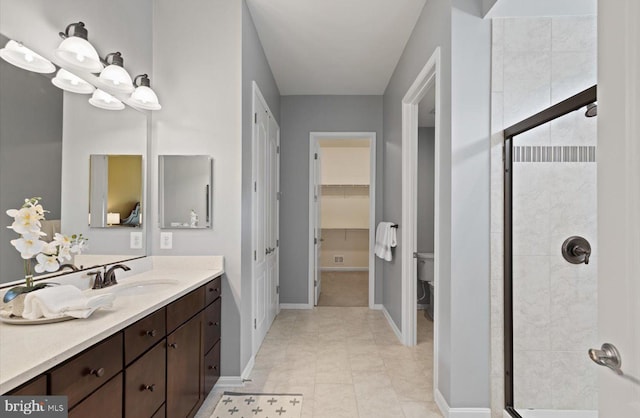 bathroom with vanity, toilet, tile patterned flooring, and a shower with door