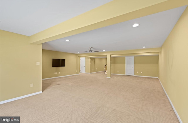 basement featuring ceiling fan and light colored carpet