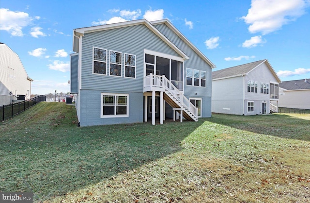 back of house with a sunroom and a lawn