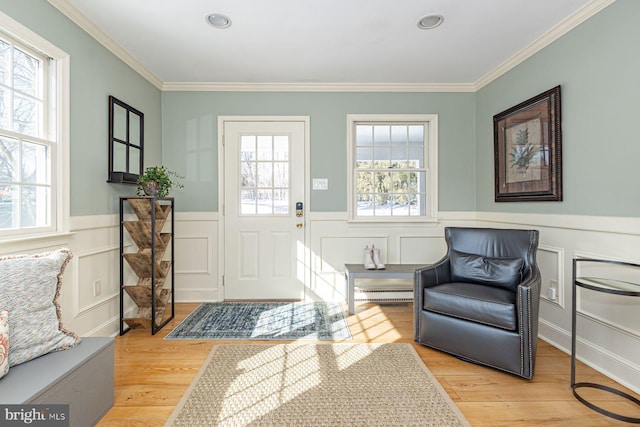 foyer featuring light hardwood / wood-style flooring, crown molding, and a wealth of natural light