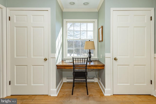 home office featuring crown molding, light wood-type flooring, built in desk, and baseboard heating