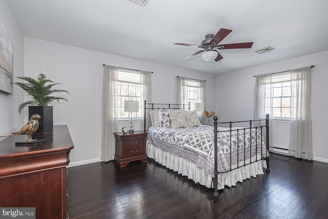 bedroom featuring dark wood-type flooring, ceiling fan, and a baseboard radiator