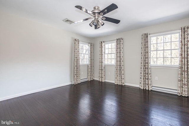 spare room featuring dark hardwood / wood-style flooring, plenty of natural light, a baseboard heating unit, and ceiling fan