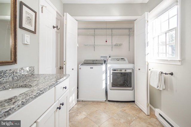 clothes washing area featuring washer and dryer, sink, and baseboard heating