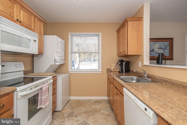 kitchen with sink, white appliances, and stacked washer / drying machine