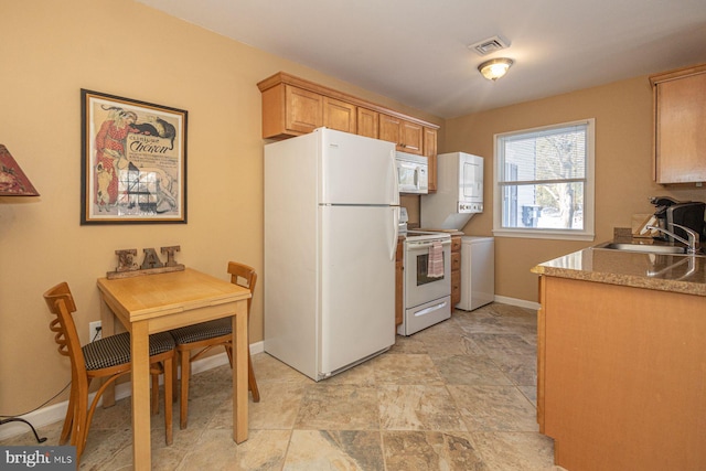 kitchen with sink, light brown cabinets, and white appliances