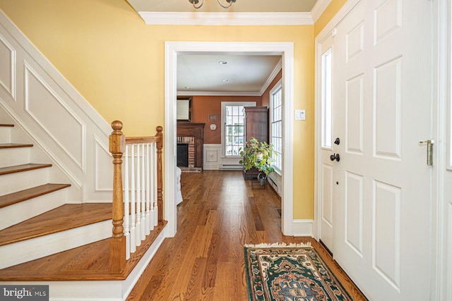 entryway featuring ornamental molding, a brick fireplace, and dark hardwood / wood-style flooring