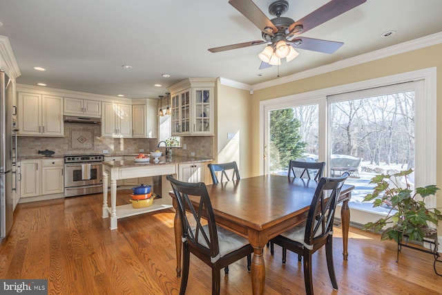 dining room featuring crown molding, ceiling fan, plenty of natural light, and light hardwood / wood-style floors