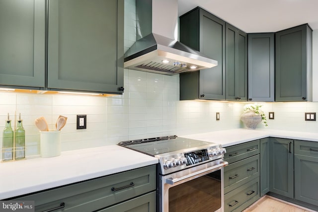 kitchen with stainless steel electric range oven, light hardwood / wood-style flooring, decorative backsplash, and exhaust hood