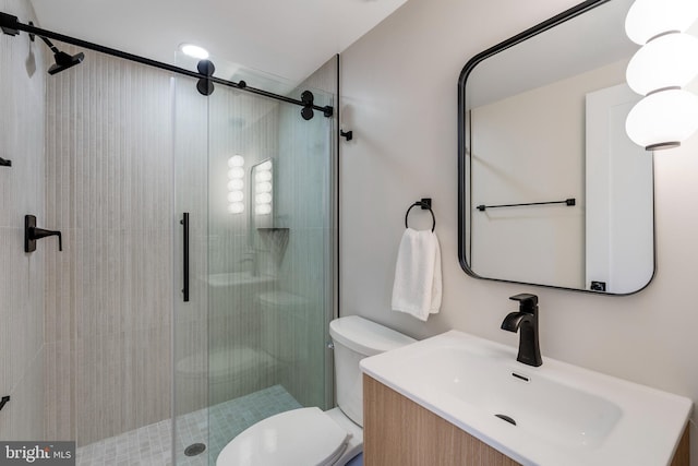 bathroom featuring vanity, toilet, and an enclosed shower