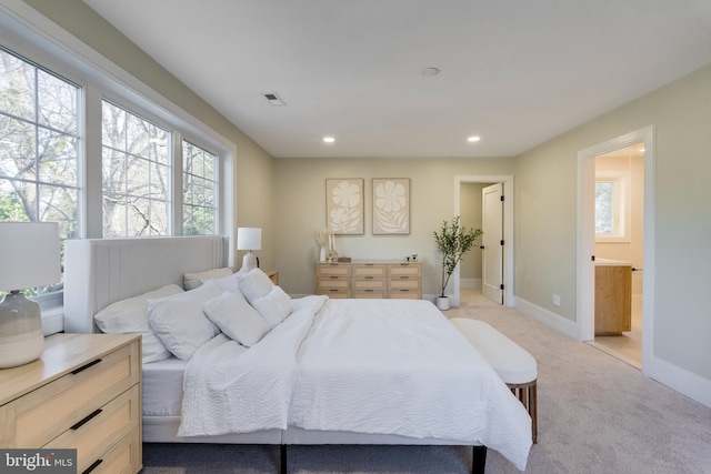 bedroom featuring light colored carpet and ensuite bathroom