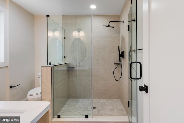 bathroom featuring walk in shower, vanity, and toilet