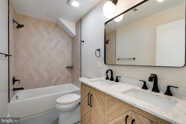 full bathroom with vanity, tiled shower / bath combo, and toilet