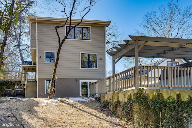 rear view of house with a wooden deck, central AC, and a pergola