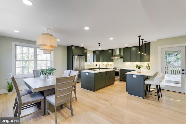 dining area featuring plenty of natural light, sink, and light hardwood / wood-style flooring